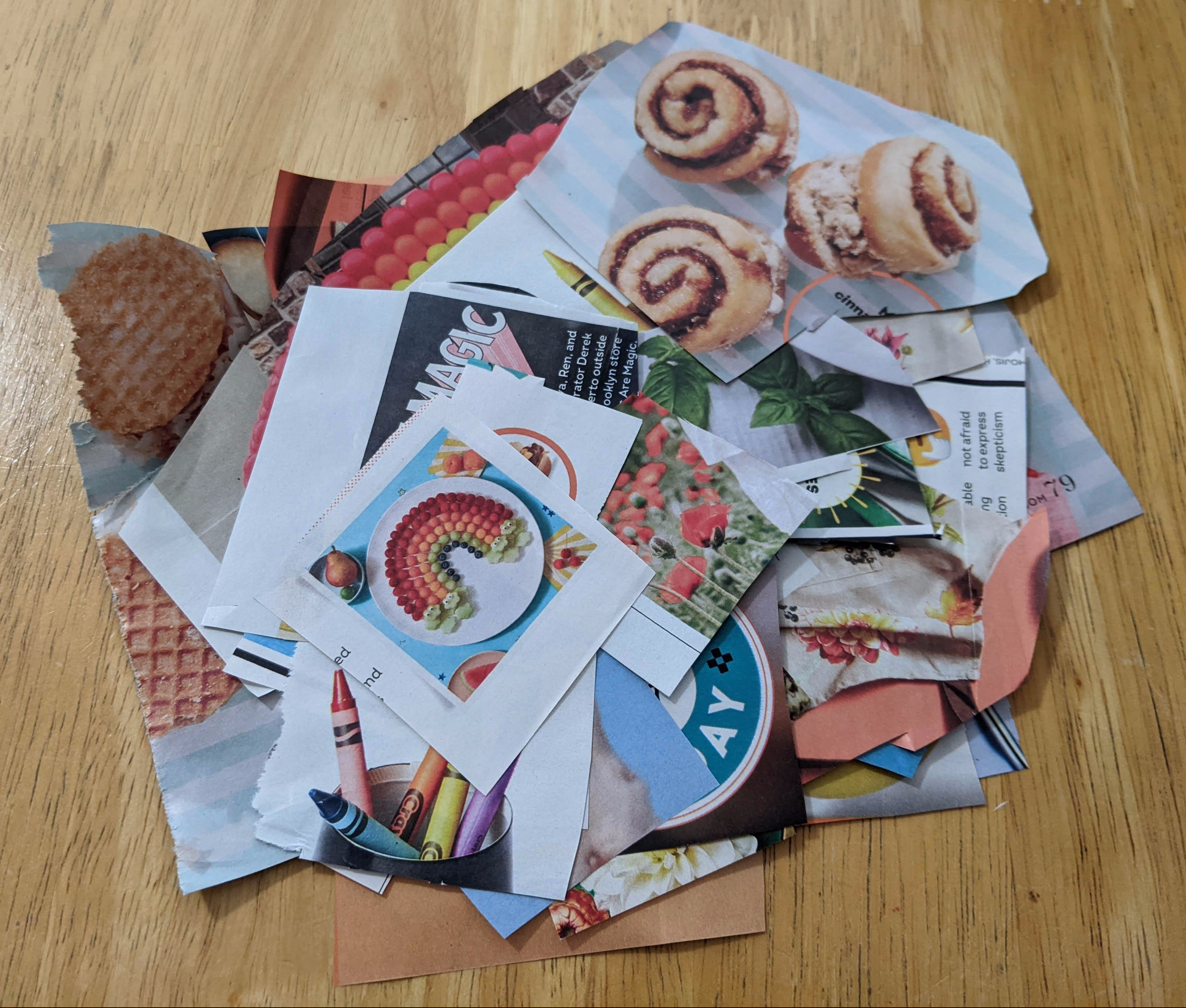 pile of pictures cut out of magazines on a blond wooden table